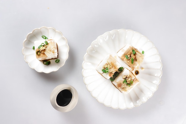 Hiyayakko is Japanese Food made from Chilled Tofu with topping like grated ginger and bonito flakes.