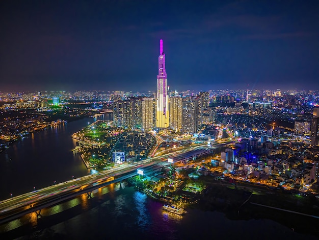 Ho Chi Minh city Vietnam DEC 10 2022 Aerial sunset view at Landmark 81 it is a super tall skyscraper and Saigon bridge with development buildings along Saigon river cityscape in the night