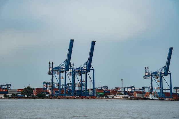 Ho Chi Minh VIETNAM FEB 19 2022 Transportation for export import at Cat Lai port on Sai Gon river crane load container to boat this harbor is big industry service for trade