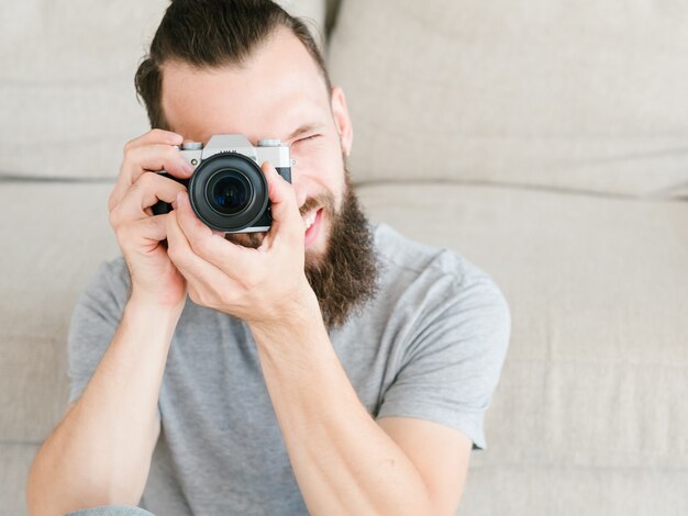 Photo hobby creativity and inspiration. photographer leisure and lifestyle. man holding photo camera in hands and looking through lens.