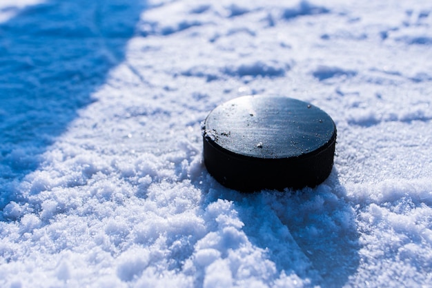 Hockey puck lies on the snow macro