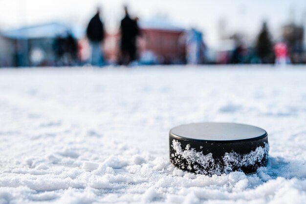 Hockey puck lies on the snow macro