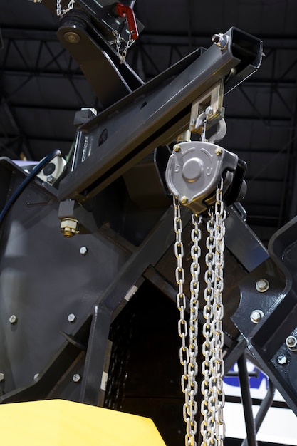 Hoist with chain in swing arm of machinery