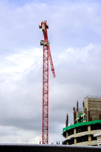 Hoisting crane and Construction crane working building construction on bright blue sky