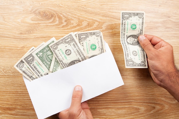 holding an envelope with banknotes at the table