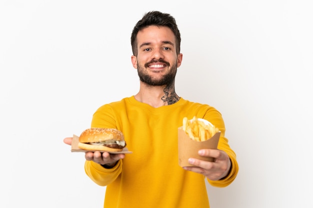 Holding fried chips and cheeseburger over isolated background