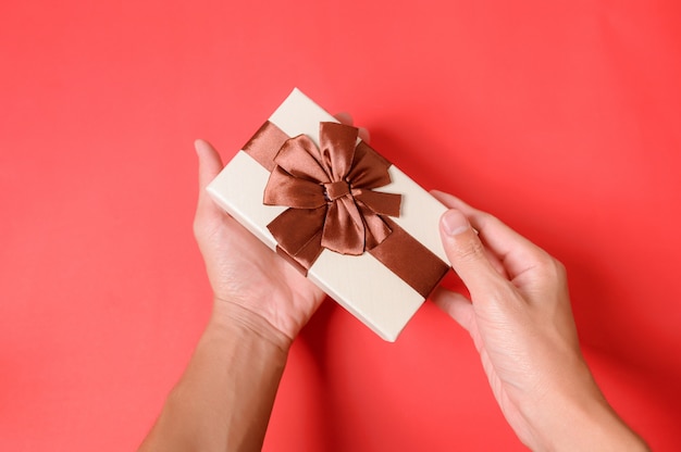 Holding a gift box with two hands.