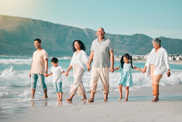 Holding hands family is walking on beach and ocean generations and bonding in nature with waves Grandparents parents and kids people outdoor and travel with trust and love on Mexican holiday