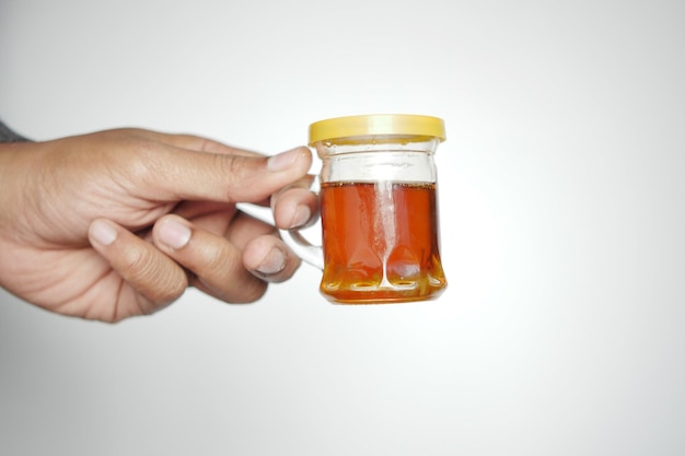 Holding honey jar against white background