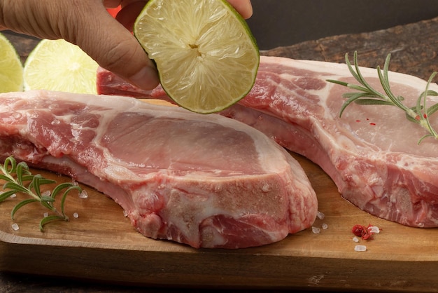 Holding lemon on raw pork prime rib Selective focus