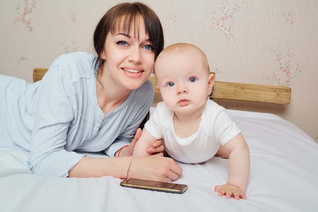 Holding little child healthy toddler and mom mother and baby closeup portrait happy faces adorable child mom and kid having fun indoor parents joy