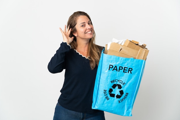 holding a recycling bag full of paper to recycle