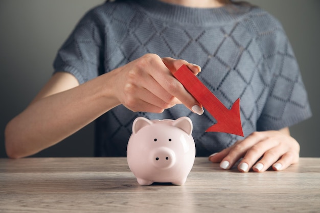 Holding Red Arrow In Front Of Pink Piggybank