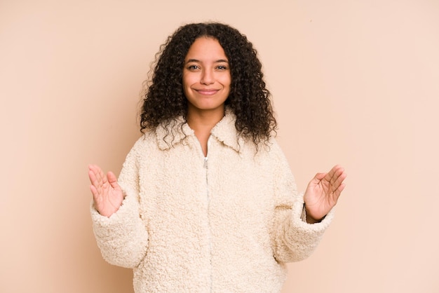 Holding something little with forefingers smiling and confident