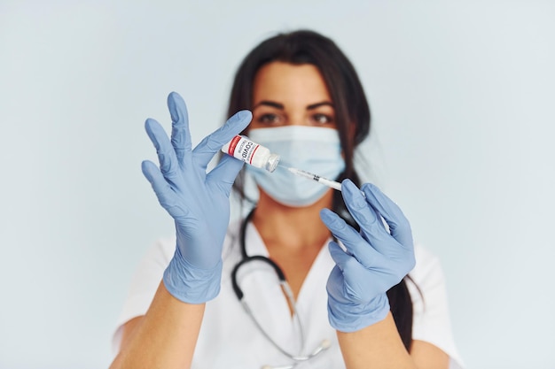 Holding test tube Young female doctor in uniform is indoors