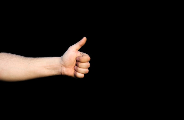 Holding thumb up with like sign. Isolated on black background.