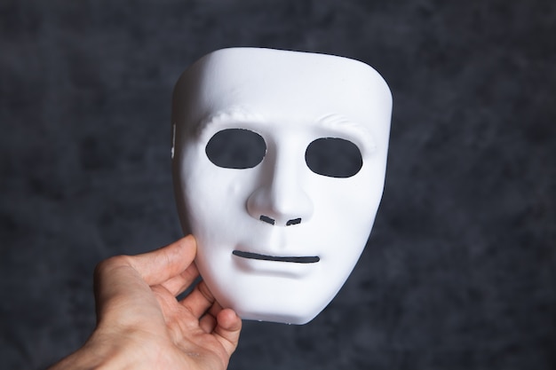 Holding a white anonymous mask