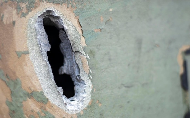 Hole or hole armor deformation from a projectile closeup Damaged armor of a Russian armored