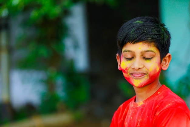 Holi celebrations -Indian little boy playing Holi and showing face expression.