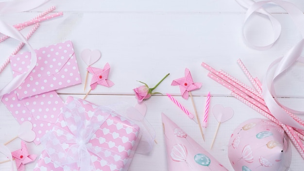 Holiday attributes in pink on a white wooden background