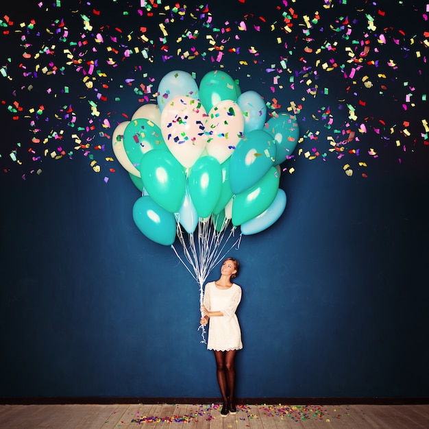 Photo holiday background with young woman,  balloons and confetti