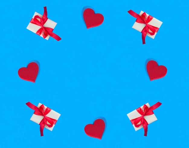 Holiday backgroundRed hearts and gift box on the blue background Copy space Top view