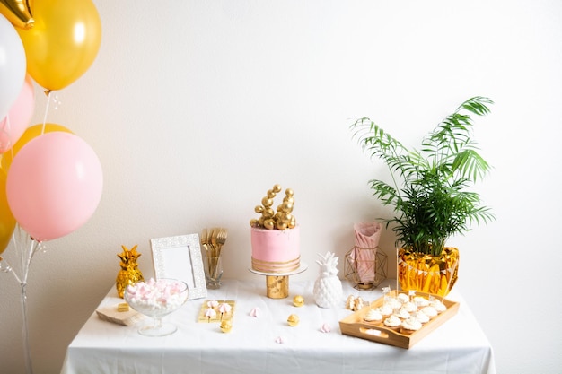 Holiday birthday table with cake and ballons pink and golden decoration