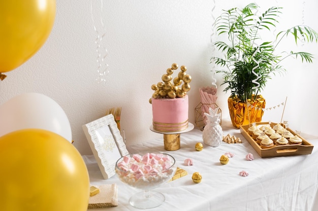 Holiday birthday table with cake and ballons pink and golden decoration