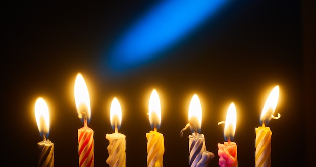 Holiday candles in a row on dark background