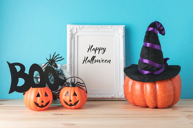 Holiday concept with Halloween pumpkin decor and photo frame on wooden table