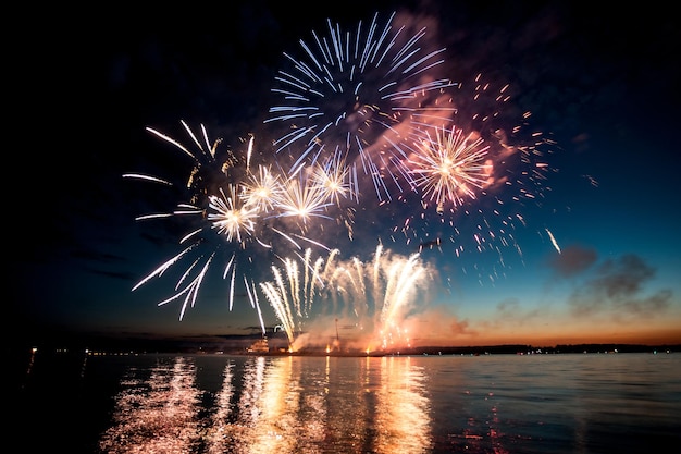 Holiday fireworks above water with reflection on the black sky background ok