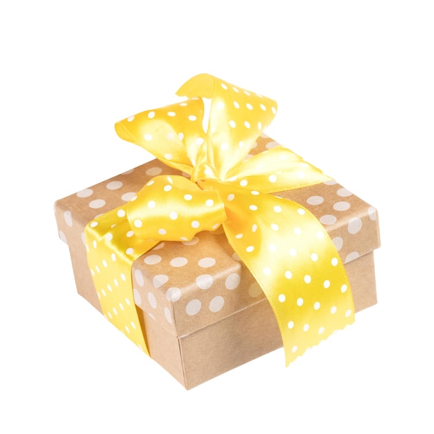 Holiday gift box in polka dot pattern with yellow bow isolated on white background