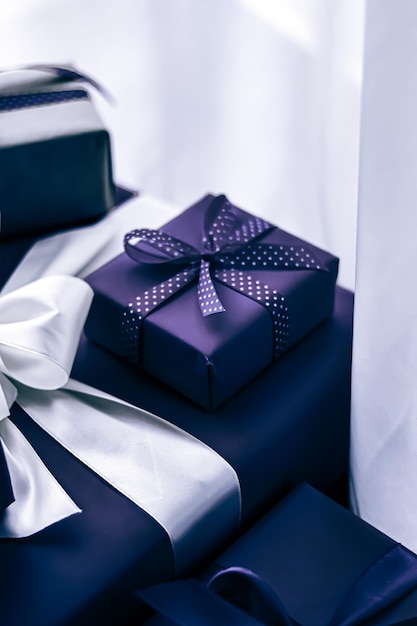 Photo holiday gifts and wrapped luxury presents purple gift boxes as surprise present for birthday christmas new year valentines day boxing day wedding and holidays shopping or beauty box delivery