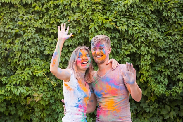 Holiday, holi and people concept - Happy couple having fun covered in paint.