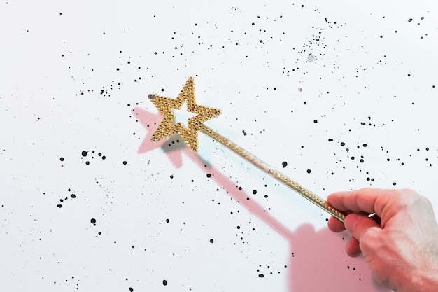 Holiday magic Gold star wand on white spotted background Fairy spell