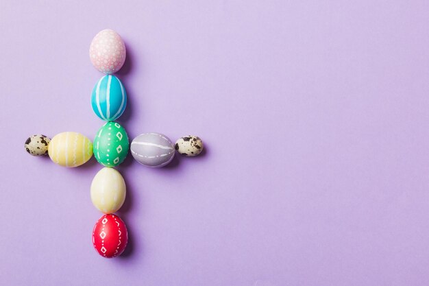 Holiday preparation Multi colors Easter eggs on colored background cross show the religious and secular side of Easter Pastel color Easter eggs holiday concept with copy space