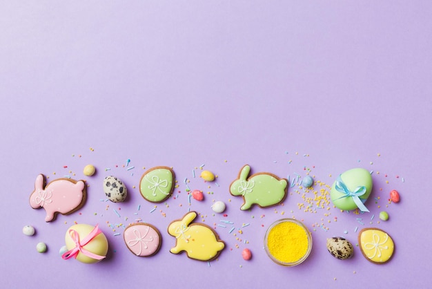 Holiday preparation Multi colors Easter eggs with cookies on colored background Pastel color Easter eggs holiday concept with copy space