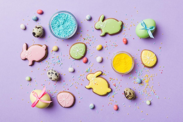 Holiday preparation Multi colors Easter eggs with cookies on colored background Pastel color Easter eggs holiday concept with copy space