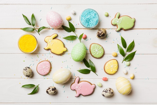 Holiday preparation Multi colors Easter eggs with cookies on colored background Pastel color Easter eggs holiday concept with copy space