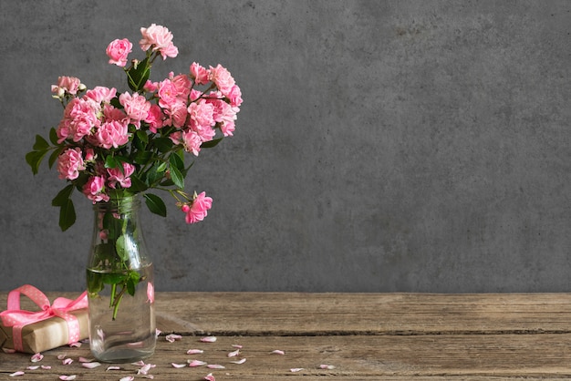 Holiday or wedding card. still life with pink rose flowers bouquet and gift box.