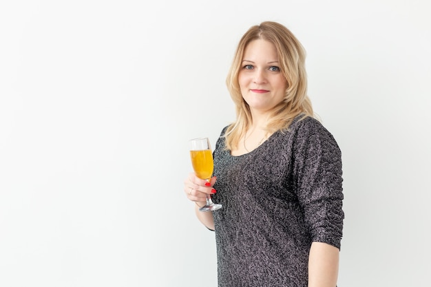 Holidays, christmas, birthday and new year concept - Woman celebrate and holds wine in a glass and sparkler over white background, close-up