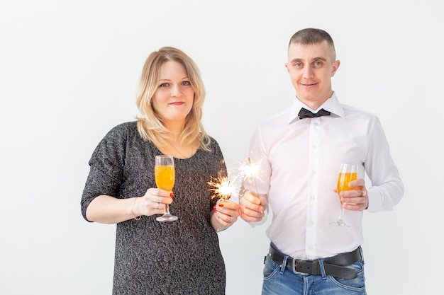 Holidays, christmas, valentine's day and new year concept - Woman and man celebrate and holds wine in a glass over white background.