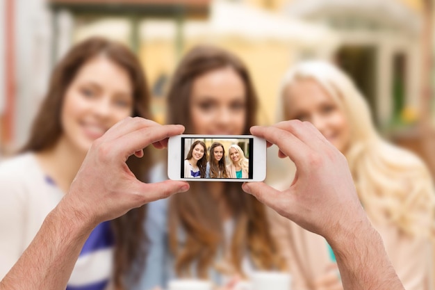 holidays, electronics and tourism concept - close up of man hands taking picture with smartphone camera