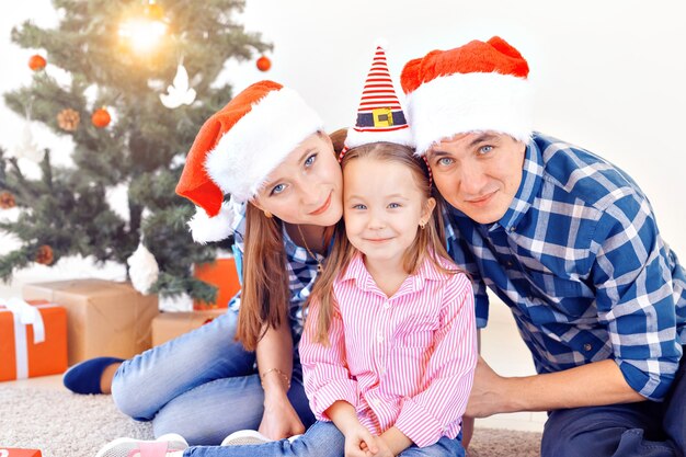 Holidays and festive concept - Happy family portrait by Christmas tree.