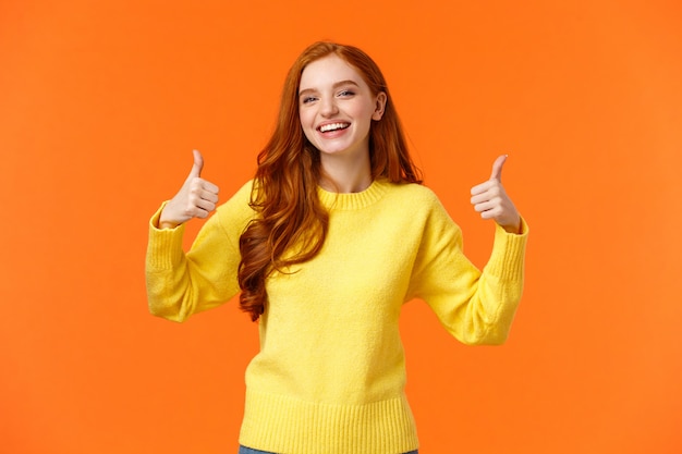 Holidays, gestures, people concept. Cheerful cute redhead girl smiling and showing thumbs-up