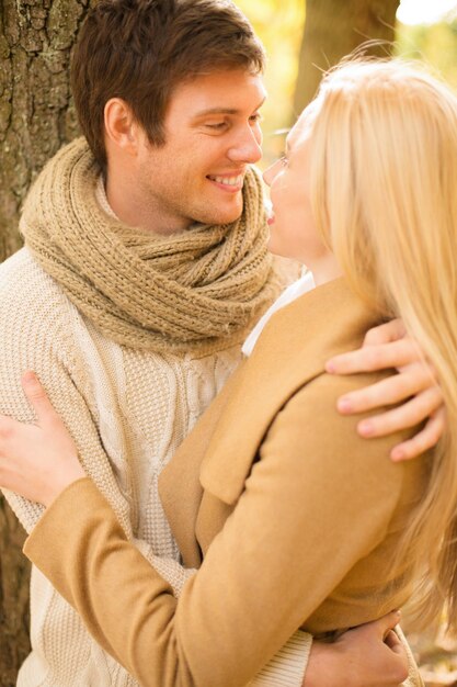 Photo holidays, love, travel, tourism, relationship and dating concept - romantic couple kissing in the autumn park