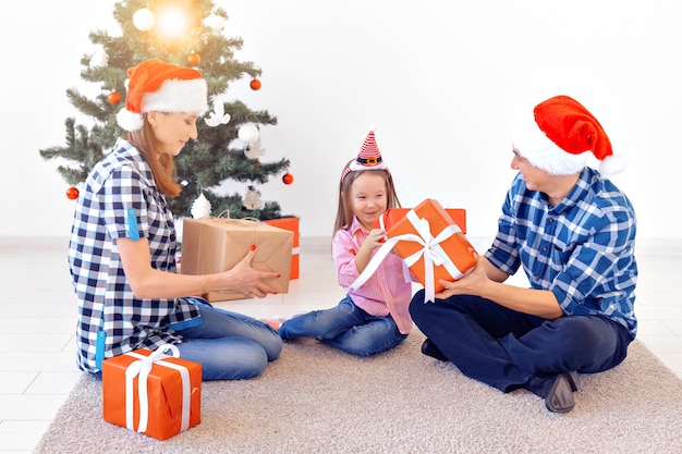 Holidays and presents concept - Portrait of a happy family opening gifts at Christmas time.