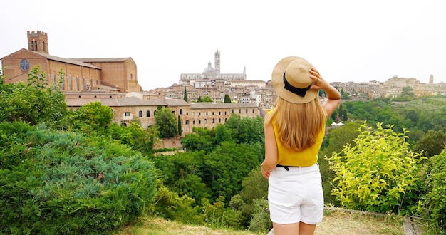 Holidays in Tuscany Panorama with young woman enjoying scenic view from tuscan hills in Siena Tuscany Italy