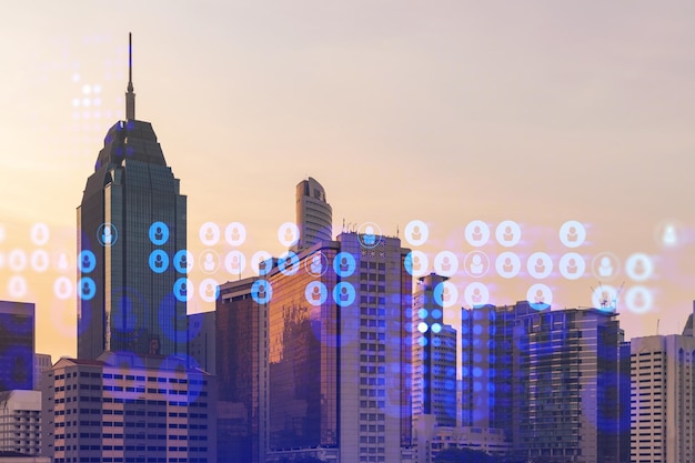 Hologram of social media icons over sunset panoramic cityscape of Kuala Lumpur Malaysia Asia The concept of people connections and career opportunities in KL Multi exposure