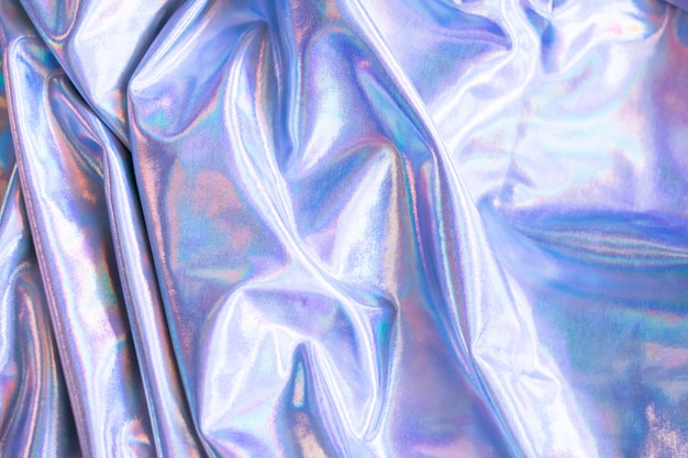 Holographic iridescent mermaid foil texture background. Futuristic neon trendy silver colors